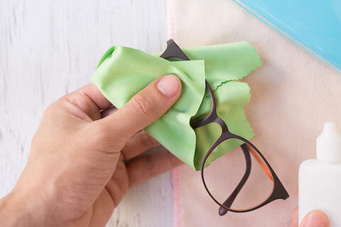 Close up of cleaning glasses with a cloth
