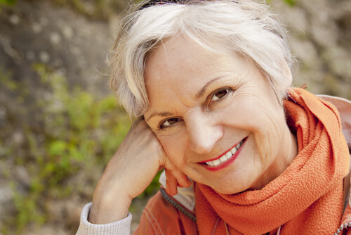 Mature woman smiling and leaning on hand