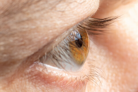 Close up view of they eye with lighting on the surface of the cornea