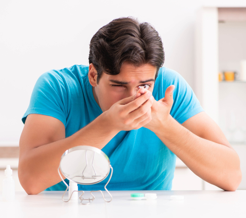 Man trying to put in contact lenses 